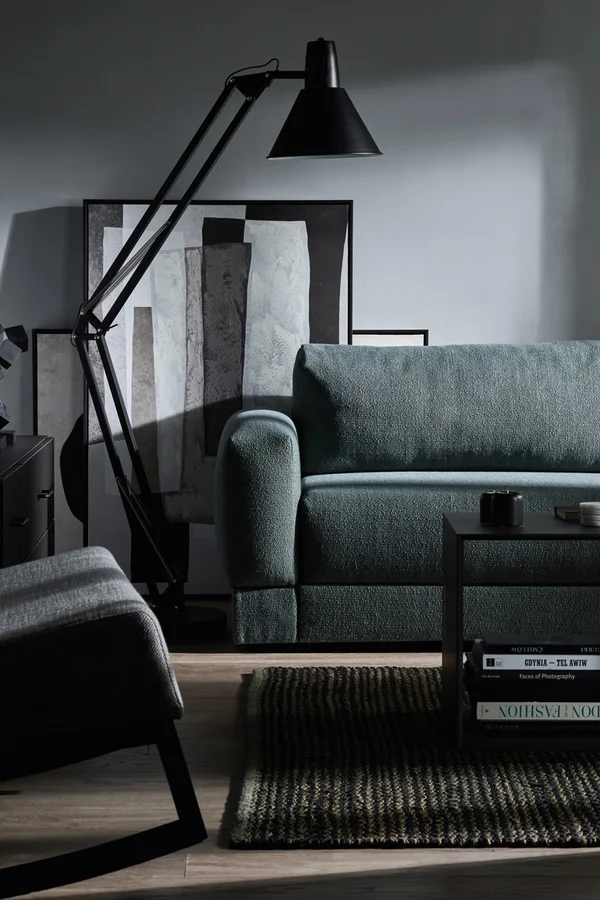 Stylowy salon z czarną lampą i sofą w odcieniach szarości